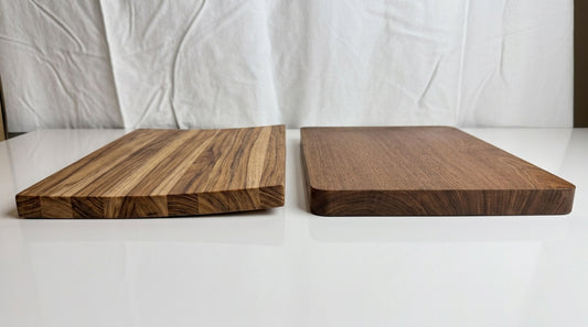 Severely warped edge-grain cutting board next to a flat solid wood cutting board