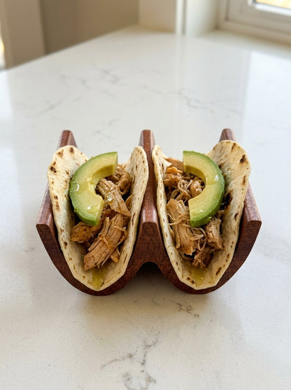 Solid mahogany double taco holder with chicken and avocado tacos, front view on marble counter
