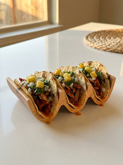 Solid oak triple taco holder loaded with al pastor tacos, pineapple chunks and cilantro garnish