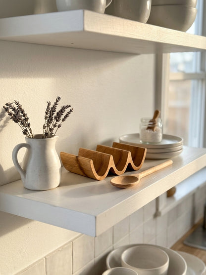 Solid oak triple taco holder displayed on open kitchen shelf with ceramics and dried lavender