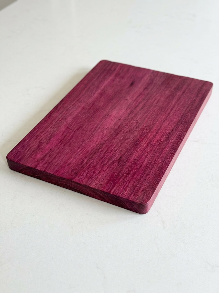 Purple heart cutting board angled view on white surface