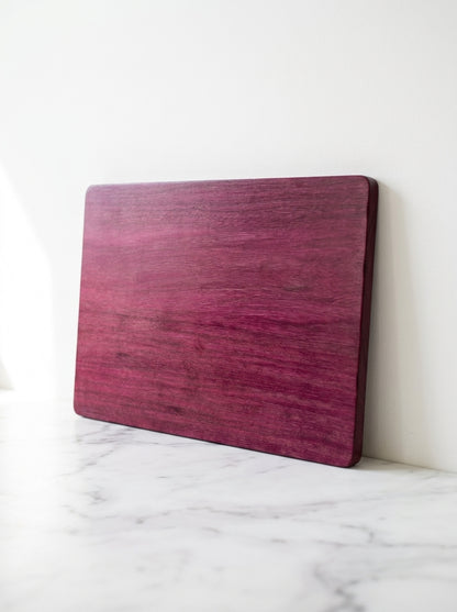 Purple heart cutting board leaning on marble counter