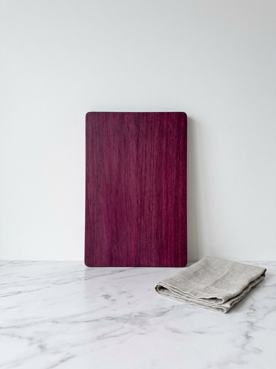 Purple heart cutting board upright with linen towel