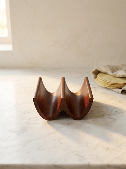 Handcrafted solid mahogany double taco holder, side profile with two carved taco slots on marble counter
