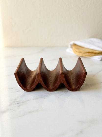 Handcrafted solid mahogany triple taco holder, side profile with three carved taco slots on marble